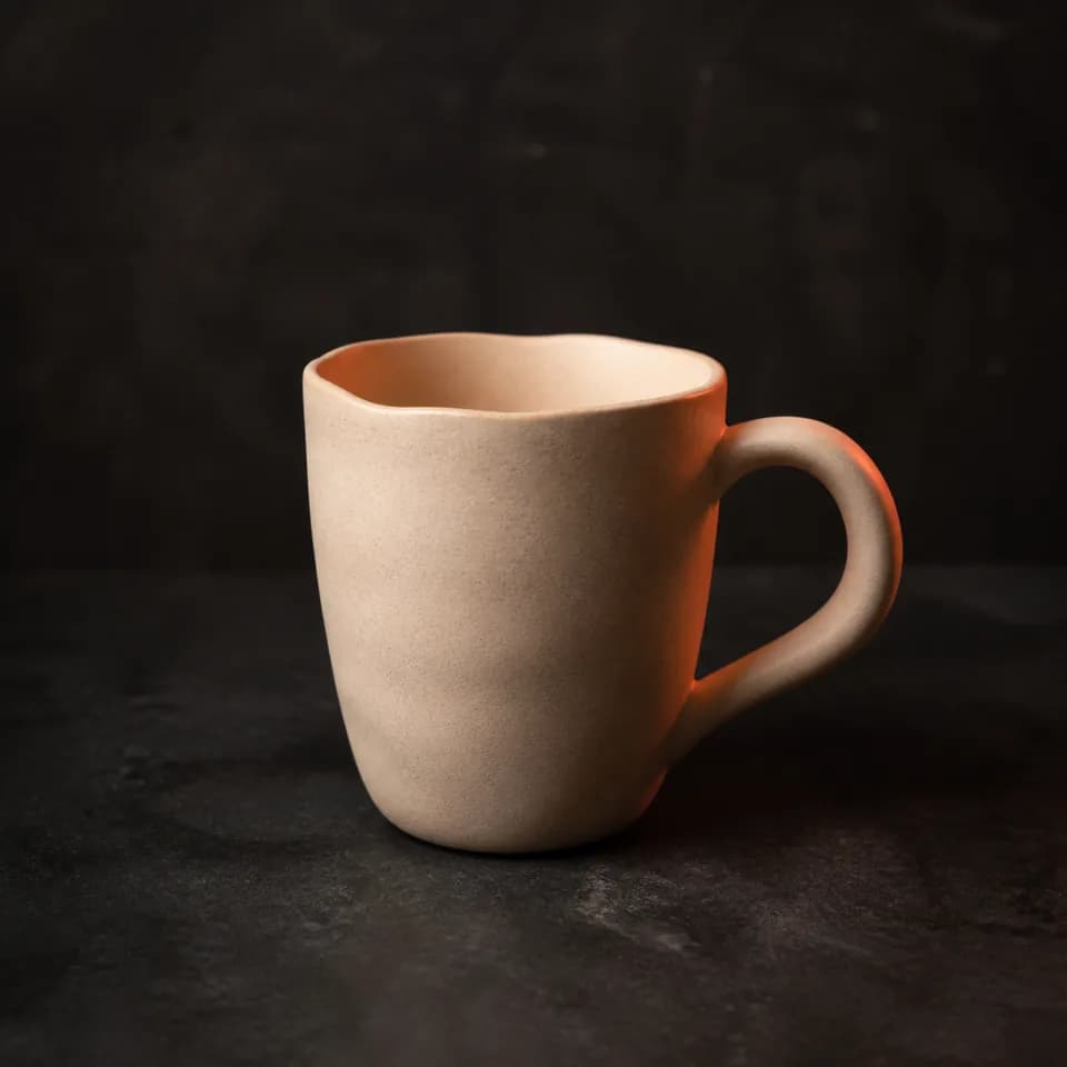 Original ceramic mug demonstration concept in warm studio light